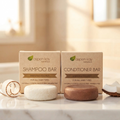 Shampoo & Conditioner Set - Coconut - Hydrating displayed with natural coconut and two conditioner bars on marble surface