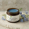 Tallow Balm Moisturizer - Blue Tansy in a glass jar with blue balm and small blue flowers on a stone surface