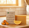 Kojic Acid & Turmeric - Bar Soap with natural ingredients, orange slice, and turmeric root on wooden surface