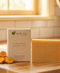 Turmeric Soap - Bar Soap with natural turmeric root slices next to branded soap packaging on wooden surface