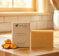 Turmeric Soap - Bar Soap with natural turmeric root slices next to branded soap packaging on wooden surface