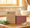 Oatmeal & Aloe - Bar Soap with natural ingredients and exfoliating oats on a wooden surface near aloe leaves